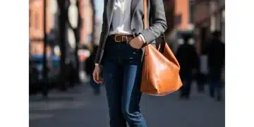 Woman in classic blazer, jeans, and leather boots, embodying timeless style and smart wardrobe choices